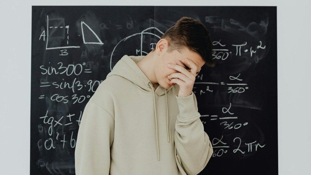 एक इन्ट्रोवर्ट लड़का बोर्ड के सामने शर्माते हुए खड़ा है।